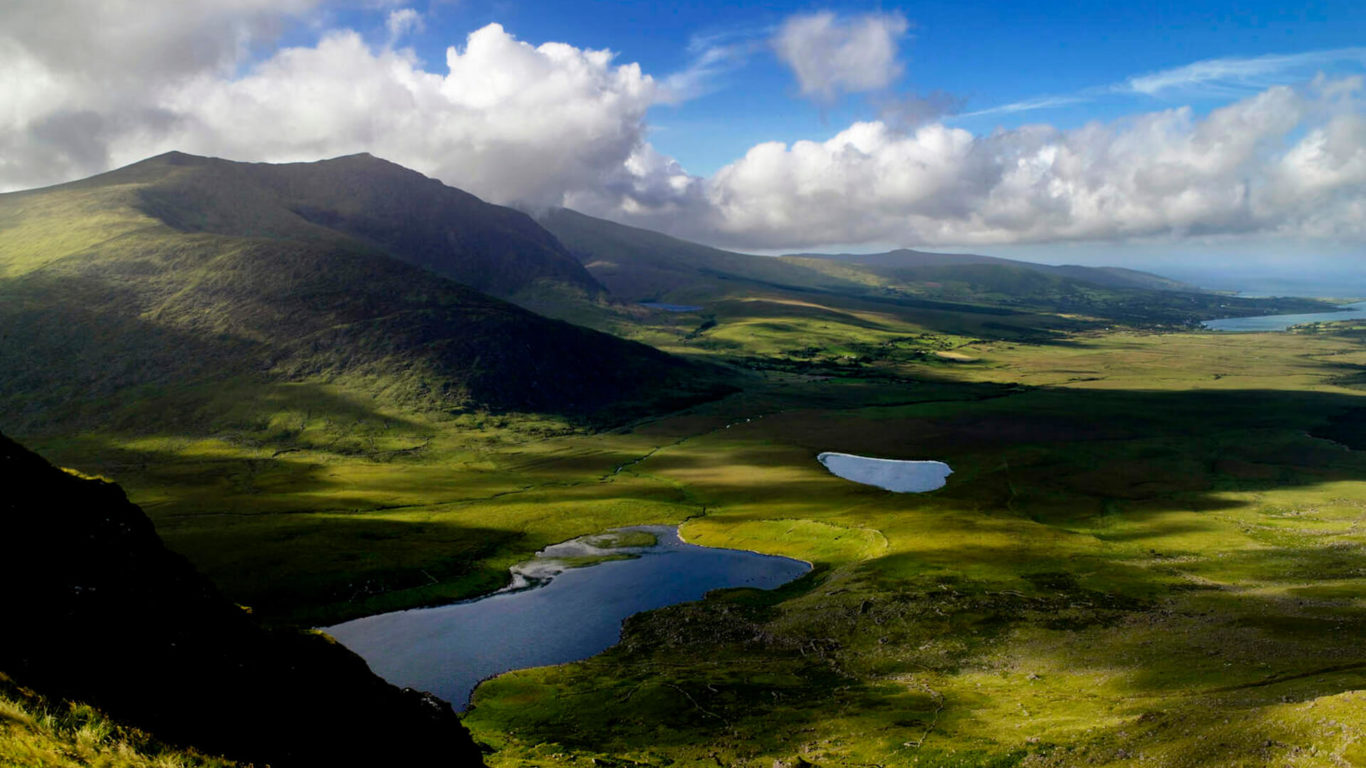 Stunning view of lush Irish mountains and serene lakes under a blue sky, perfect for nature retreats near luxury hotel.